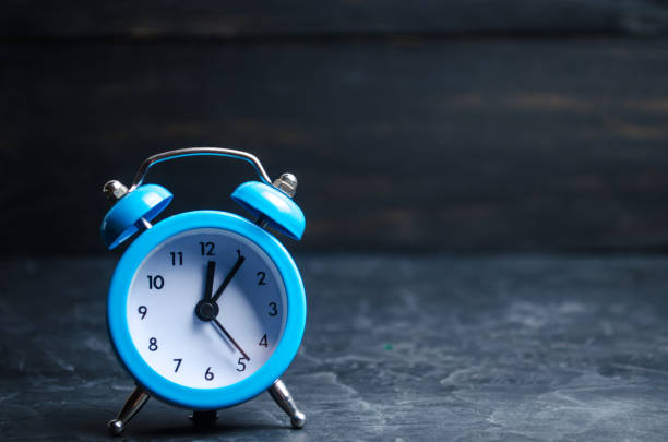 istock The blue alarm clock indicates the beginning of the first on a black background. time management. concept of the flow of time. copy space. minimalist style. 1056657816