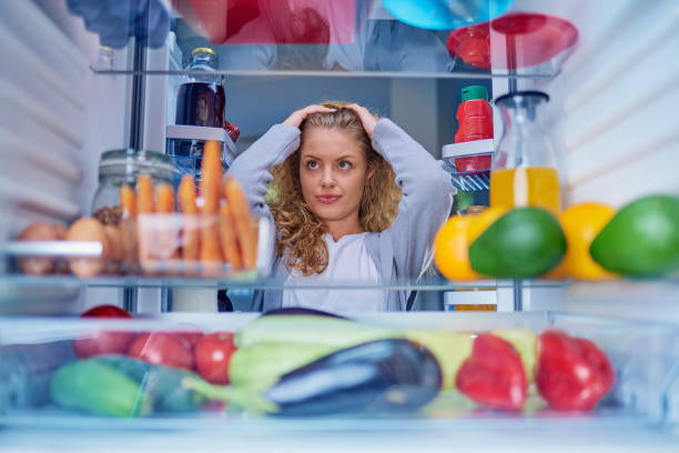 istock Confused woman choosing what to eat. 1056660182