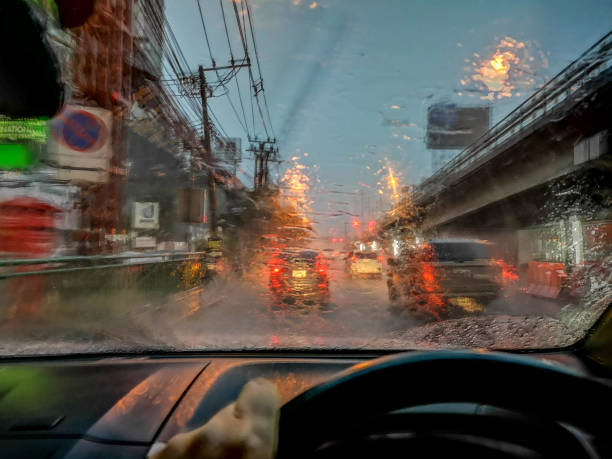 View through the windshield while driving in a traffic jam in the rain on Ramkhamhaeng Road in the heart of Bangkok. View through the windshield while driving in a traffic jam in the rain on Ramkhamhaeng Road in the heart of Bangkok. Traffic in Bangkok is very bad in the rush hours, especially in the rain, but can be equally bad during the day and also at the weekends. Only when there are school holidays or long public holidays does the road traffic lighten. truck in rain stock pictures, royalty-free photos & images