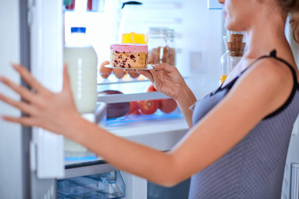 istock Woman breaking diet by taking cheesecake. 1056660488