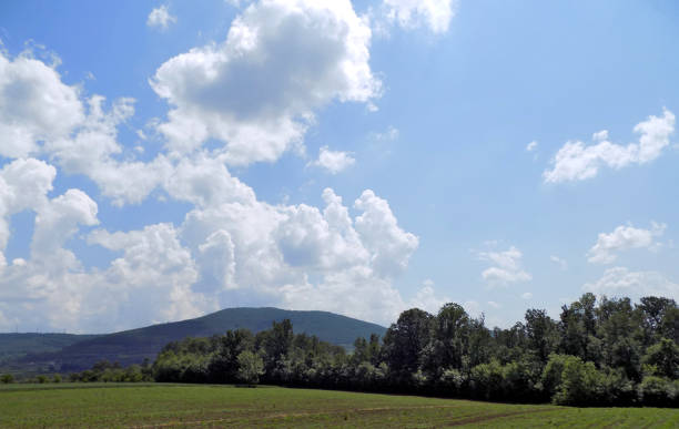 View from the road through the landscape with mountain range Landscape with mountain range autumn field tree mountain stock pictures, royalty-free photos & images