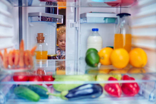istock Toddler stealing food from fridge. 1056662534