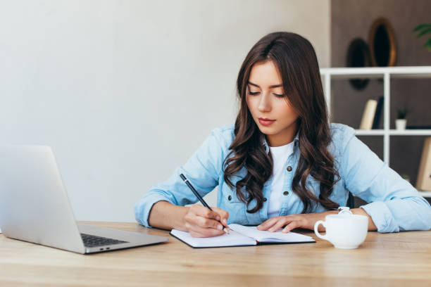 istock young woman at tabletop with laptop taking part in webinar in office 1056663540