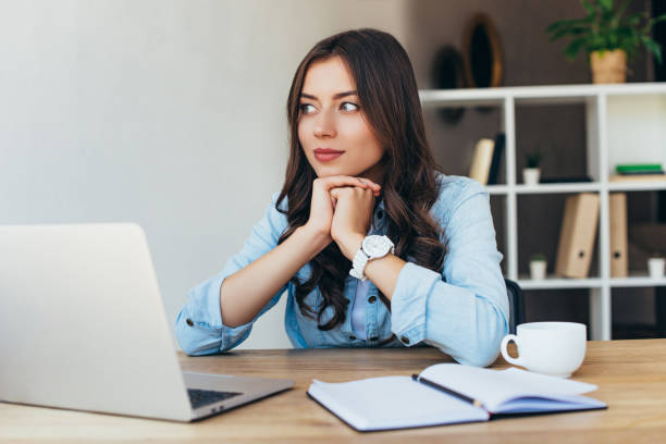 istock pensive woman at tabletop with laptop taking part in webinar in office 1056663564