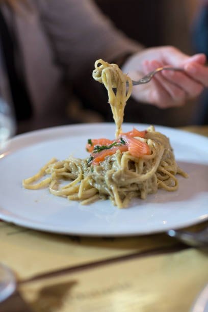 istock Woman Eating Creamy Pasta with Salmon 1056667160
