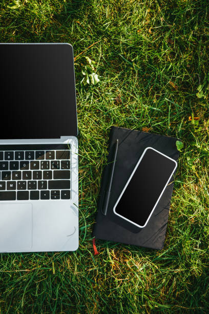 istock top view of digital devices with blank screens on green grass in park 1056670064