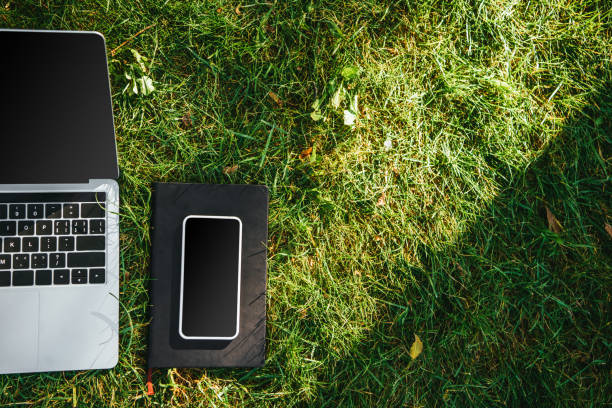 istock elevated view of gadgets with blank screens on green grass in park 1056670074