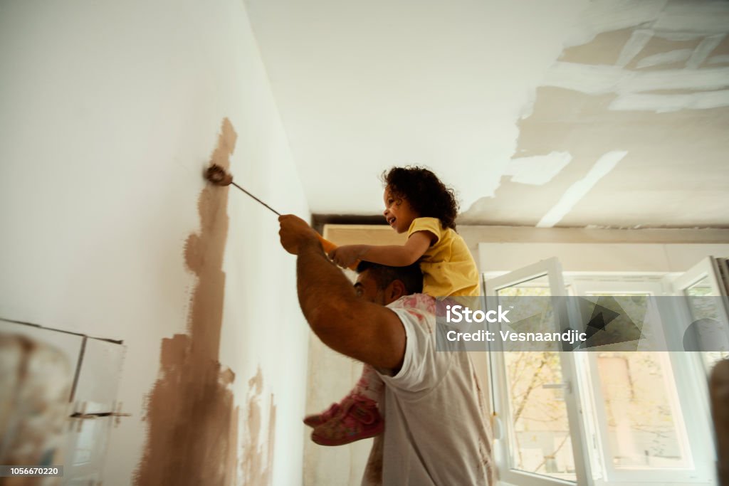 Beautiful home for beautiful family Young family renovating their home, painting wall Painting - Activity Stock Photo