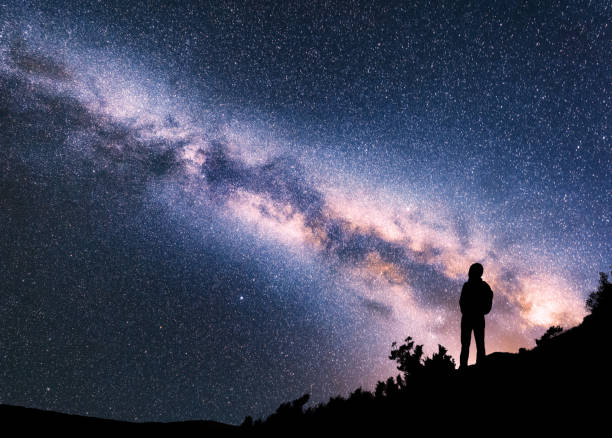 silhouette of woman with backpack on the hill against colorful milky way at night. space background. landscape with girl, bright milky way, sky with stars. amazing galaxy. travel in nepal. starry sky - milky way galaxy space star imagens e fotografias de stock