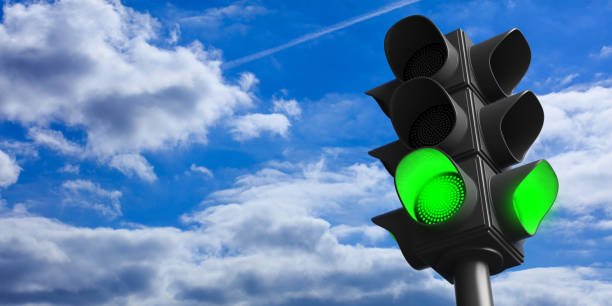 Green traffic lights on blue sky background, copy space. 3d illustration