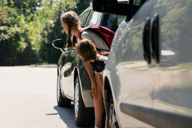 istock Children walking through the road between cars. Dangerous passage 1056676794