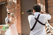 wedding photographer takes pictures of bride and groom