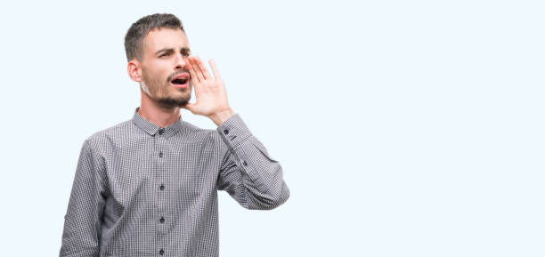 istock Young hipster man shouting and screaming loud to side with hand on mouth. Communication concept. 1056678732