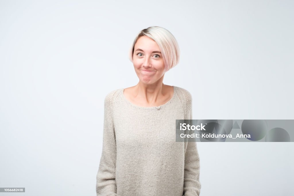 Young very unhappy woman, trying to look sorry or to complain Young very unhappy woman, trying to look sorry or to complain, studio shoot isolated on white background Explaining Stock Photo