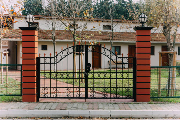 istock Garden Gate, Path. Openwork leaf steel doors to the garden plot. Black wrought gate to property with garden in the background. Front door, double black front door with a secured front entrance 1056682850