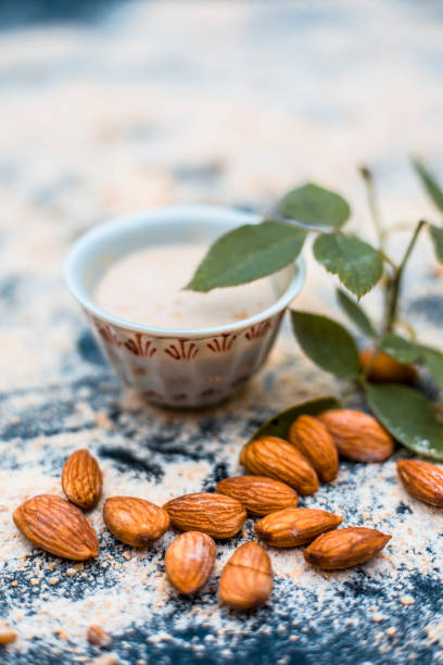 Close up of oats face pack or Avena sativa facial mask i.e crushed or powdered almonds or badam,milk and grounded oats on wooden surface.This face pack is widely used in spa for de-tanning. cerca de la mascarilla de avena o avena sativa máscara facial, es decir, triturado o en polvo, almendras o badam, leche y conectado a tierra avena sobre superficie de madera. esta mascarilla es ampliamente utilizado en spa para el bronceado.