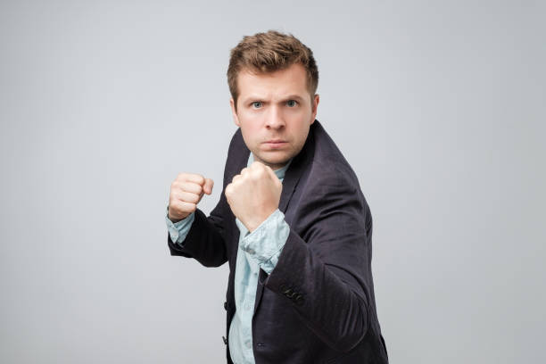 istock Confident businessman ready for fight over gray background. 1056683970
