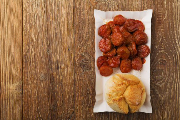 istock Traditional German currywurst, served on disposable paper tray with a fresh bun. 1056690082