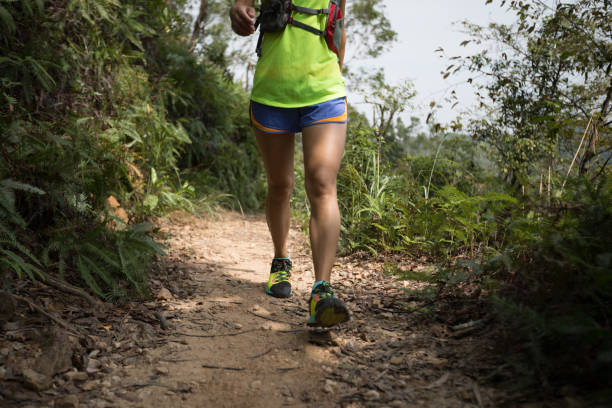 istock Young woman trail runner walking on tropical forest trai 1056697854