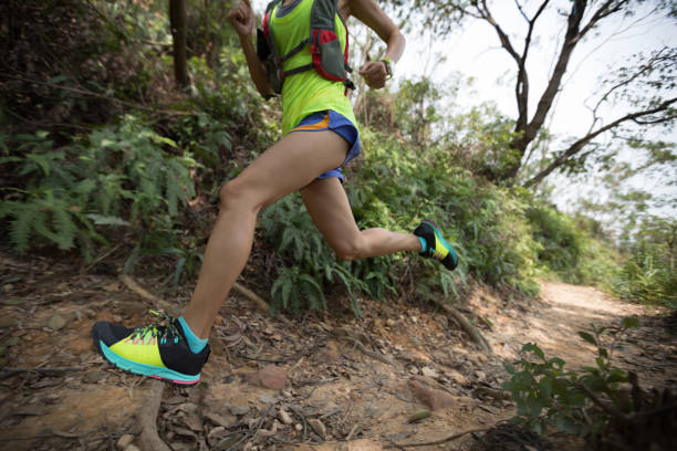 istock Young woman trail runner running on tropical forest trai 1056699068