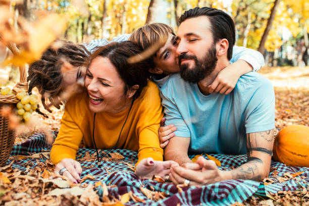 Beautiful family having fun, lying on a picnic carpet