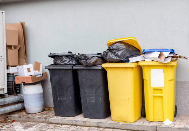 istock Overflowing plastic waste cans with garbage bags, cardboard boxes and a container with a liquid 1056707042