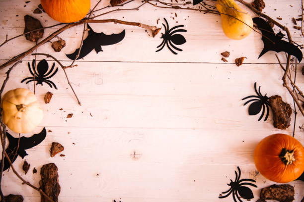 istock Halloween background with copy space, decorated with pumpkins, spiders, bats and tree branches 1056707636
