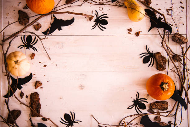 istock Halloween background with copy space, decorated with pumpkins, spiders, bats and tree branches 1056707638