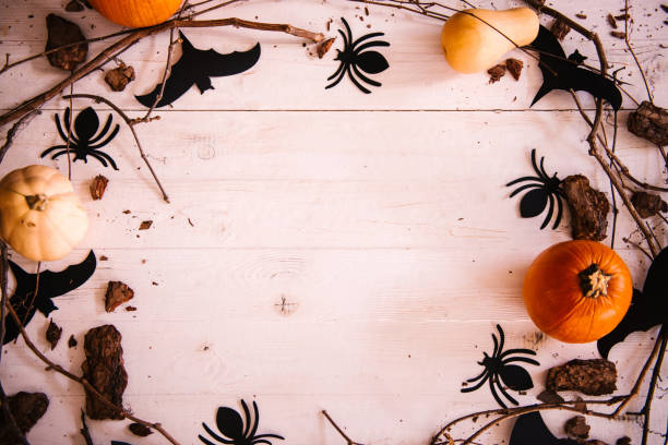 istock Halloween background with copy space, decorated with pumpkins, spiders, bats and tree branches 1056707842