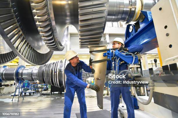 Workers Assembling And Constructing Gas Turbines In A Modern Industrial Factory Stock Photo - Download Image Now