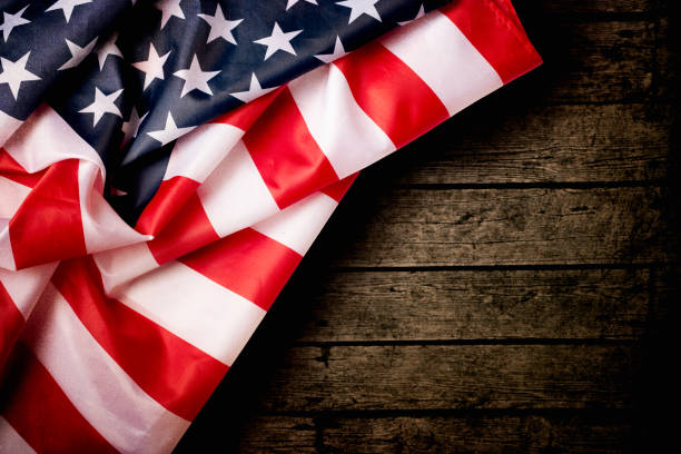 американский флаг над деревянным фоном - american flag folded usa flag стоковые фото и изображения