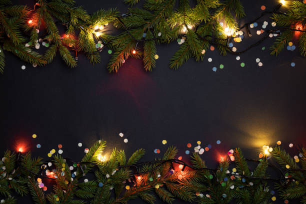 istock Christmas lights and decoration with fir tree and confetti 1056715654