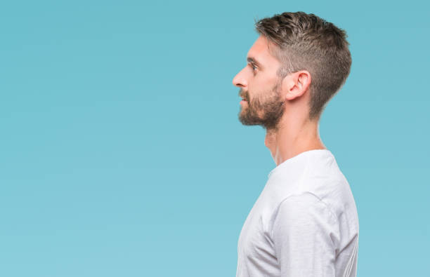 istock Young handsome man over isolated background looking to side, relax profile pose with natural face with confident smile. 1056716370