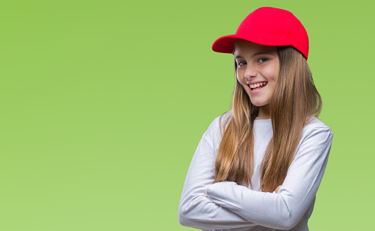 Young beautiful girl wearing red cap isolated background happy face smiling with crossed arms looking at the camera. Positive person.