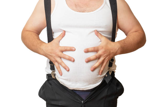 istock A man with a big belly shows his size with his hands. 1056725872