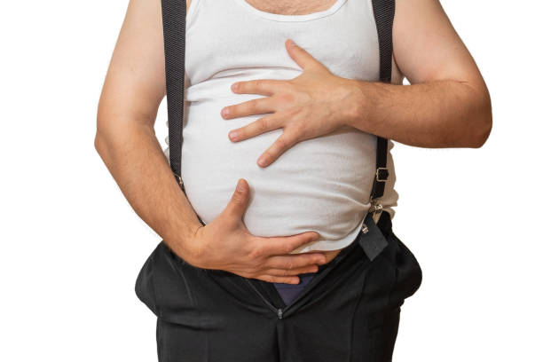 istock A man with a big belly shows his size with his hands. 1056725880