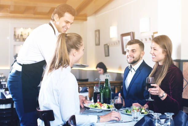 istock Waiter serving meals to friendly company guests 1056734098