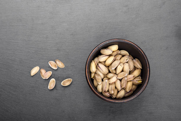 pistachios in a plate on a black background top view. space for text