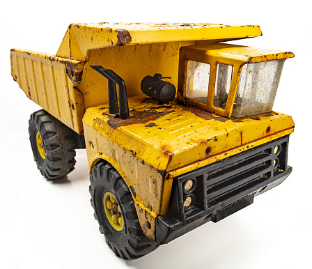 Rusted yellow toy truck isolated against white background