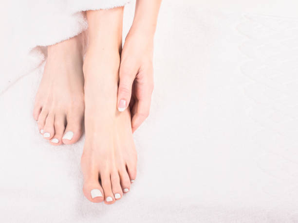 Beautiful hands and feet of healthy women on bed stock photo