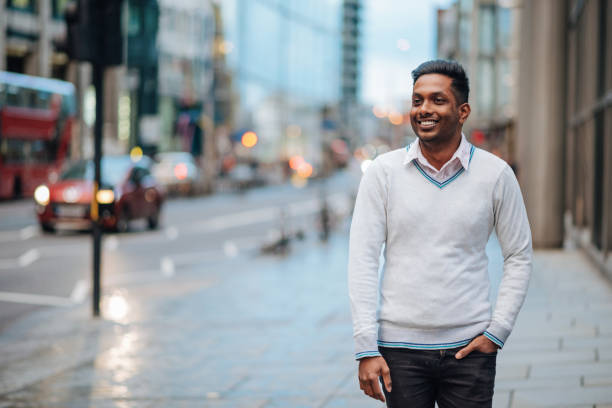 istock Smiling Indian man on rainy day in London, UK 1056745544