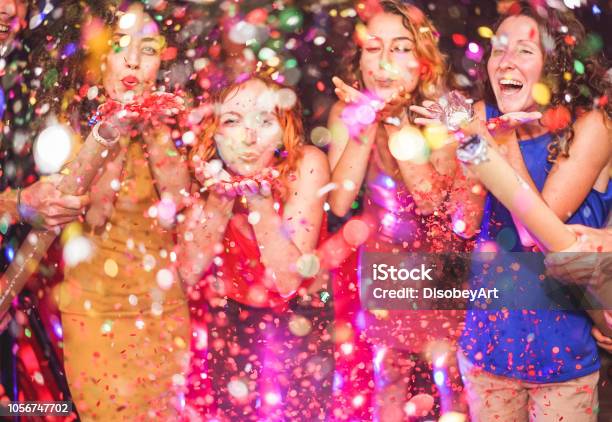 Foto de Amigos Felizes Fazendo Festa Jogando Confete Jovens Comemorando Na Noite De Fim De Semana Entretenimento Diversão Véspera De Ano Novo Vida Nocturna E Fest Conceito Foco Em Mãos De Menina De Cabelo Vermelho e mais fotos de stock de Festa