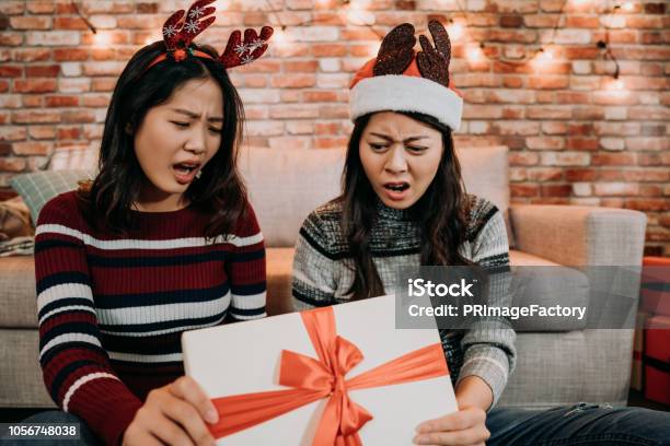 Girls Open Gift Box At Home Feeling Displeased Stock Photo - Download Image Now - Arrival, Gift, Christmas Present