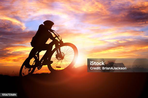 Silueta De Ciclista De Montaña En Acción Contra El Concepto De Puesta De Sol Para Deporte Y Ejercicio Foto de stock y más banco de imágenes de Ciclismo de montaña