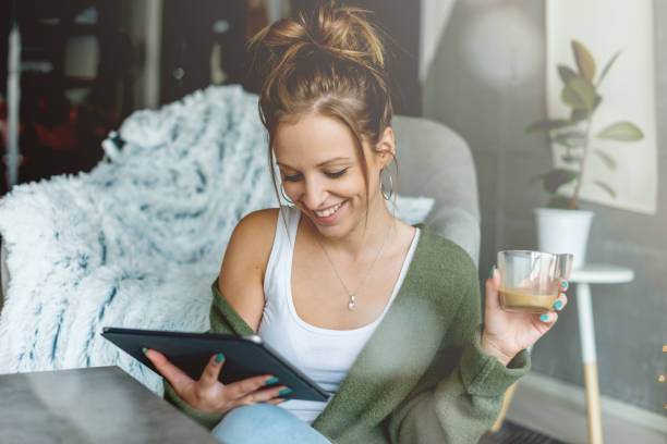 istock Smiling young woman looking at digital tablet 1056761758