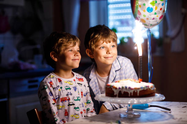 duas belas crianças, meninos pré-escola comemorando aniversário e velas - birthday cake family germany indoors - fotografias e filmes do acervo