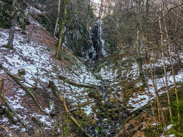 istock Frozen waterfall with icicles and a bit of streaming water in a forest landscape of Wasserfall Germany 1056767026
