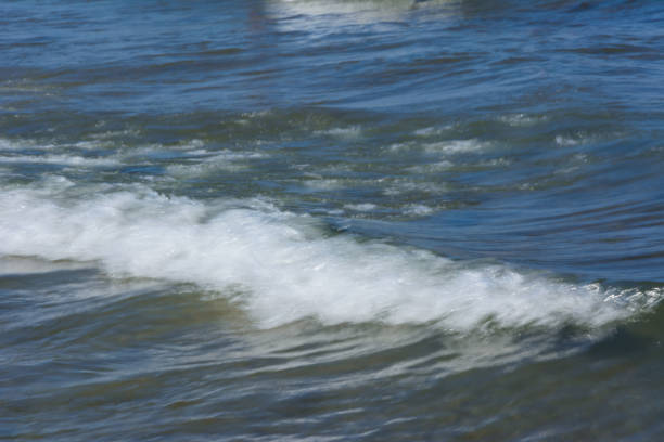istock natural background. a small running wave with foam near the shore 1056768964