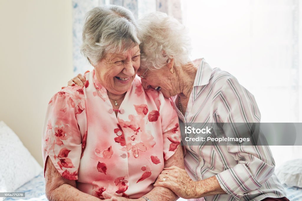 You still tickle my funny bone! Shot of two happy elderly women spending time with each other at home Senior Adult Stock Photo