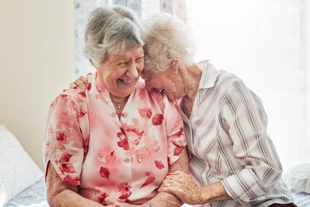 You still tickle my funny bone! Shot of two happy elderly women spending time with each other at home geriatrics stock pictures, royalty-free photos & images